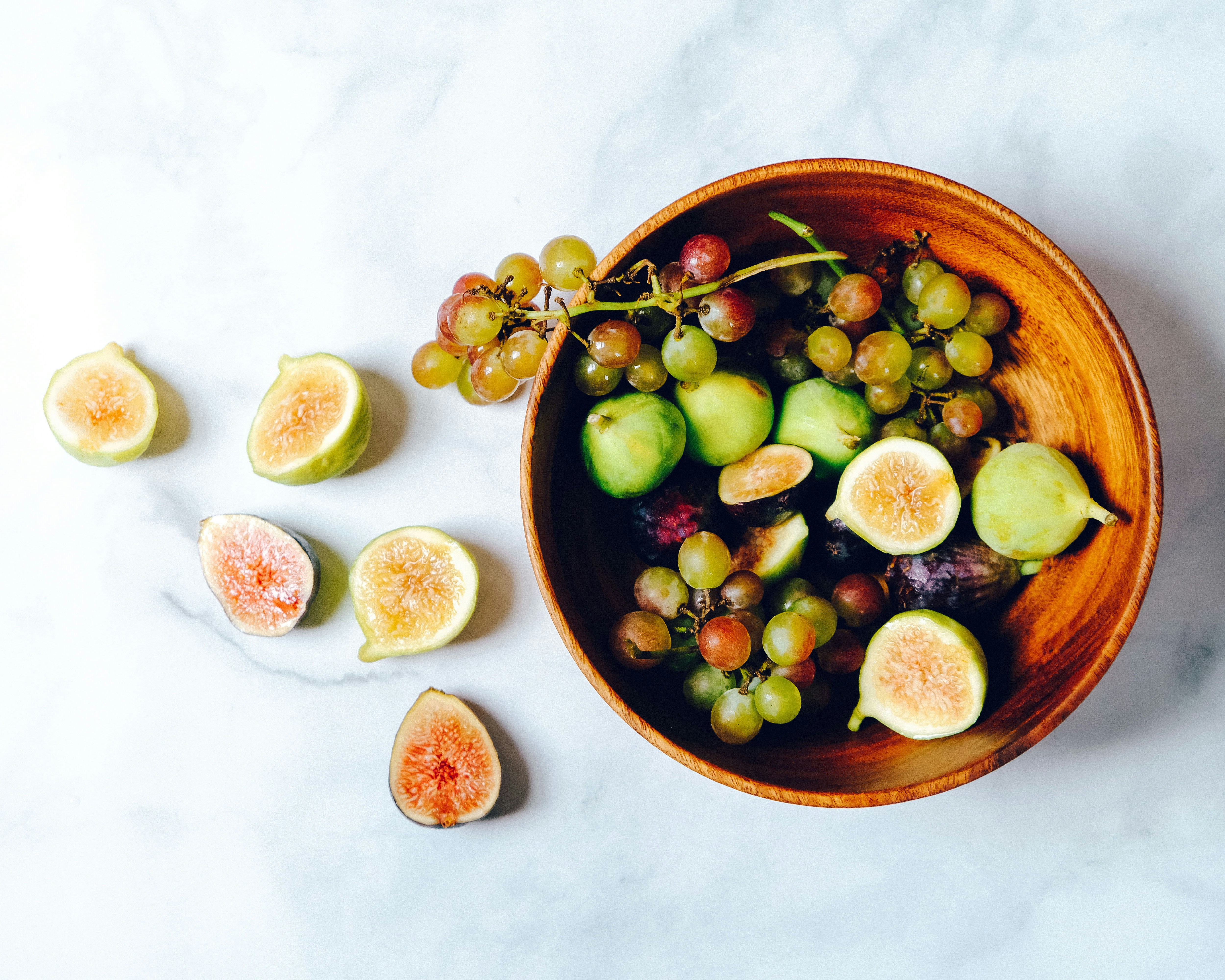 Photographie alimentaire de fruits tranches sur bol brun : une expérience maison et conviviale à vivre chez l'habitant grâce à notre plateforme.